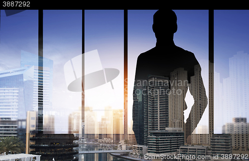 Image of silhouette of business man over city background