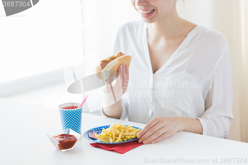 Image of close up of woman eating hotdog and french fries