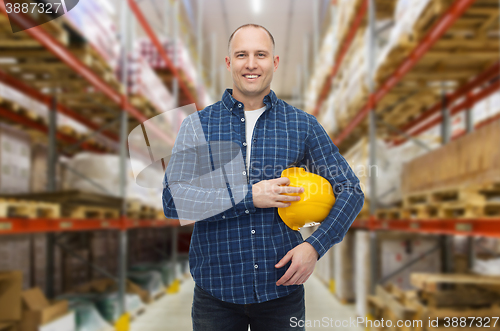 Image of happy man with hardhat over warehouse