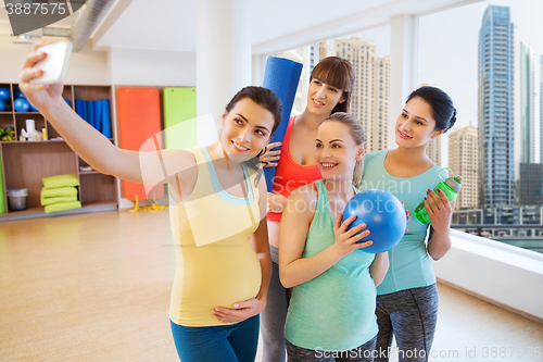 Image of pregnant women taking selfie by smartphone in gym