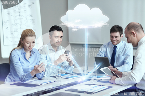 Image of smiling business people with gadgets in office