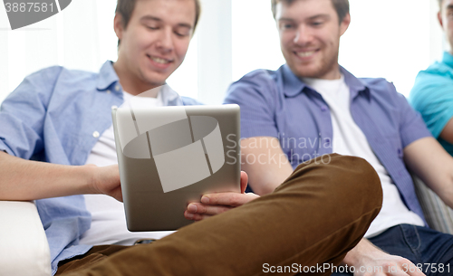 Image of close up of happy friends with tablet pc at home