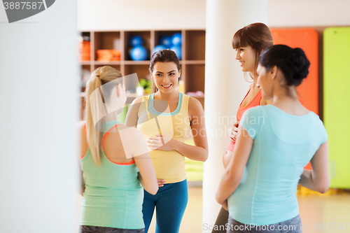 Image of group of happy pregnant women talking in gym