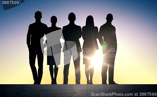 Image of business people silhouettes on stairs over sun