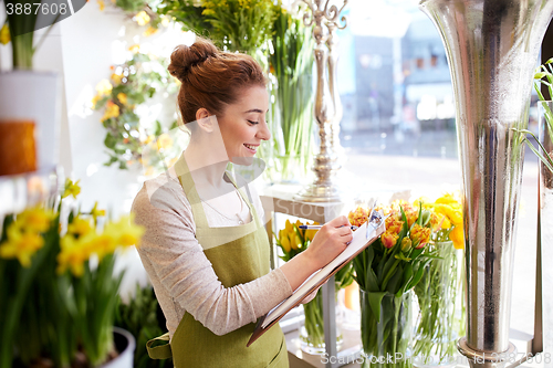 Image of florist woman with clipboard at flower shop