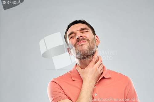 Image of man touching neck and suffering from throat pain