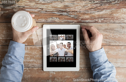 Image of close up of male hands with photo on tablet pc