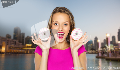 Image of happy woman or teen girl with donuts