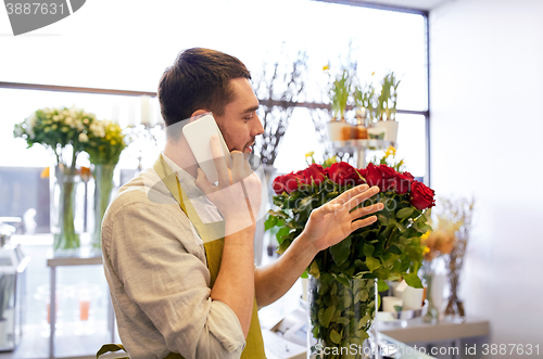 Image of man with smartphone and red roses at flower shop