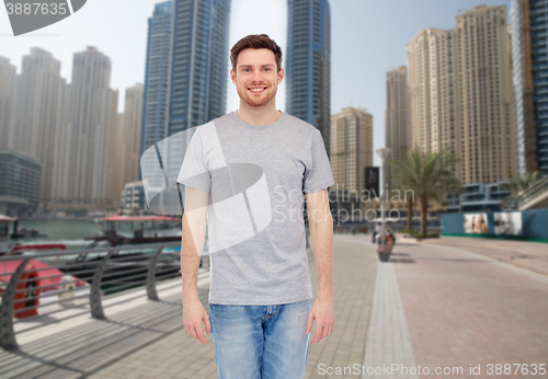 Image of young man in gray t-shirt and jeans over city 