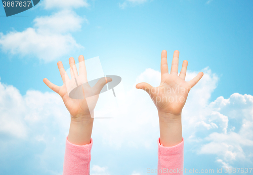 Image of close up of little child hands raised upwards