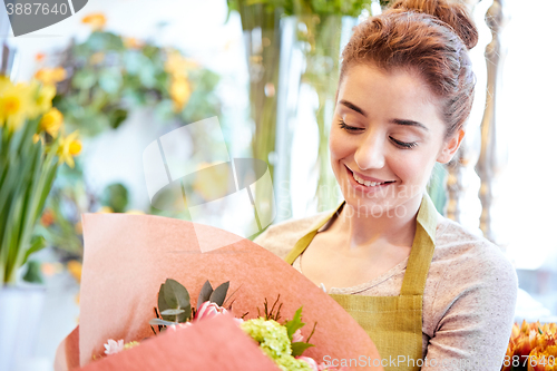 Image of smiling florist woman with bunch at flower shop