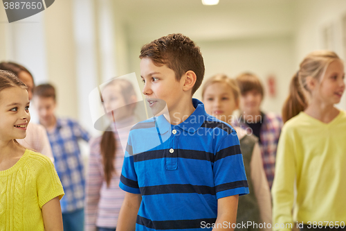 Image of group of smiling school kids walking in corridor