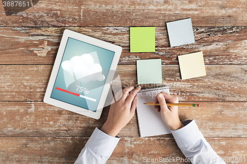 Image of close up of hands with tablet pc and notebook