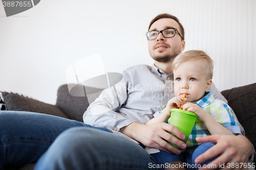 Image of father and son drinking from cup and at home