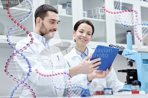 Image of scientists with tablet pc and microscope in lab