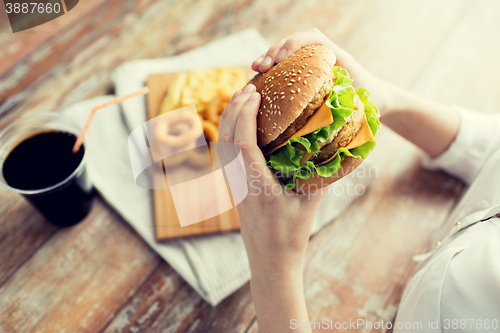 Image of close up of woman hands holding hamburger