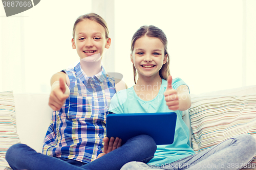 Image of happy girls with tablet pc and showing thumbs up