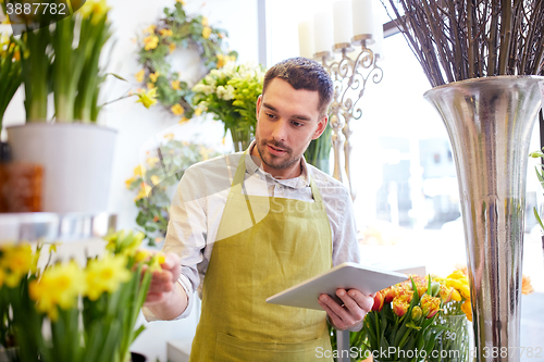 Image of man with tablet pc computer at flower shop