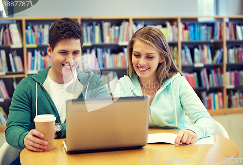 Image of happy students with laptop in library