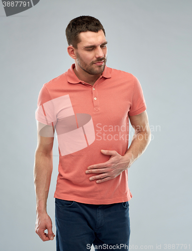 Image of unhappy man suffering from stomach ache