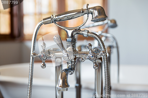 Image of close up of bath tap and shower at bathroom