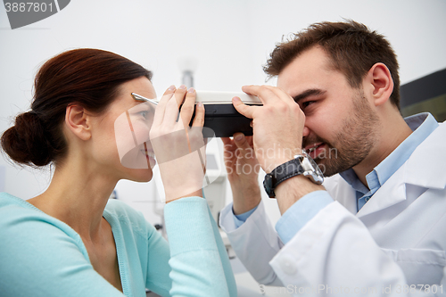 Image of optician with pupilometer and patient at eye clinic