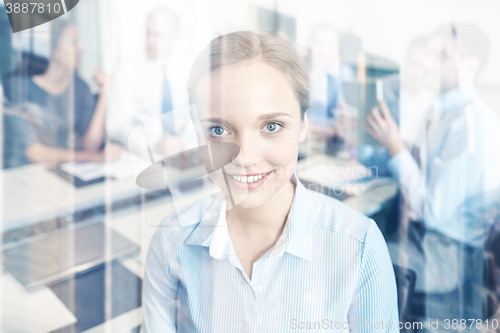 Image of group of smiling businesspeople meeting in office