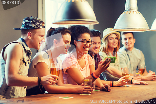 Image of happy friends with smartphone taking selfie at bar