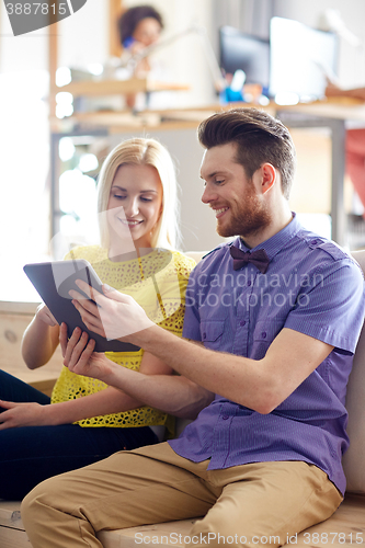 Image of happy creative team with tablet pc in office