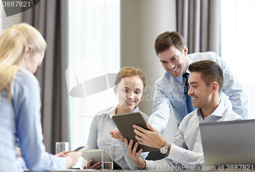 Image of smiling business people with tablet pc in office