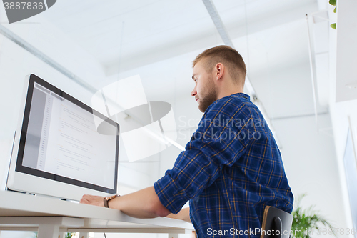 Image of creative man or programmer with computer at office