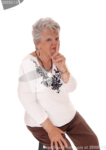 Image of Senior woman with finger over mouth.