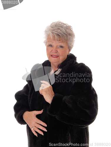 Image of Senior woman in a black fur coat.