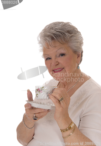 Image of Senior woman holding coffee cup.