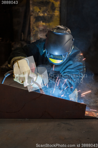 Image of worker welding metal