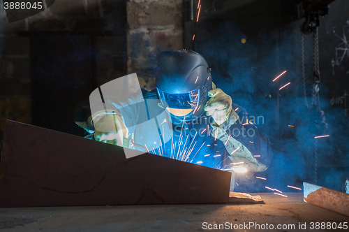 Image of worker welding metal