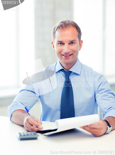 Image of businessman with notebook and calculator