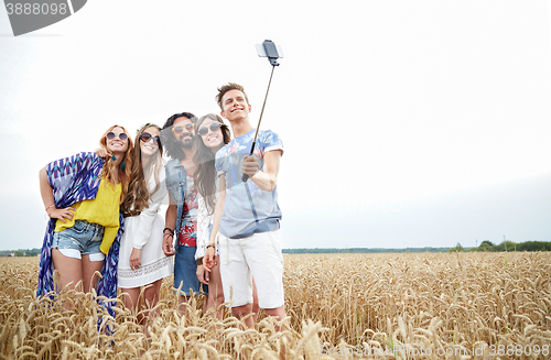 Image of hippie friends with smartphone on selfie stick