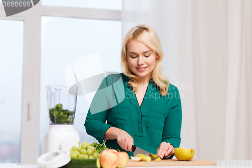 Image of smiling woman with blender cooking food at home