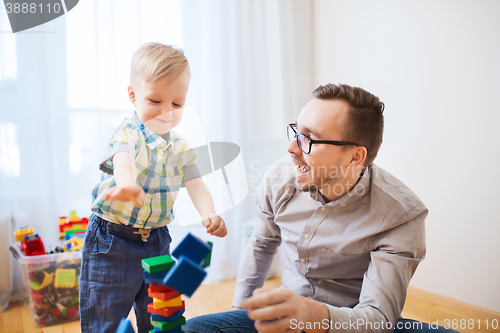 Image of father and son playing with toy blocks at home