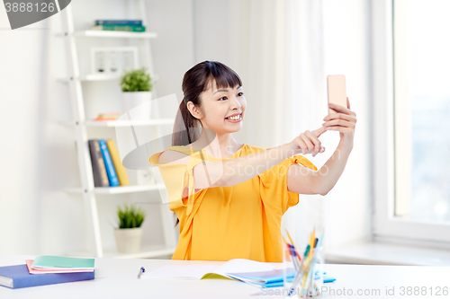 Image of asian woman student taking selfie with smartphone