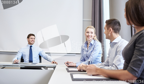Image of group of smiling businesspeople meeting in office