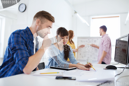 Image of creative team with blueprint at office