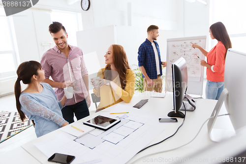 Image of happy creative team rinking coffee at office