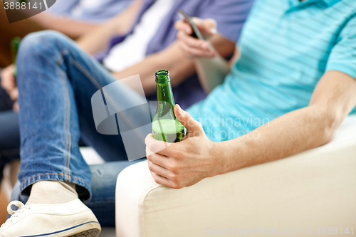 Image of close up of male friends drinking beer at home