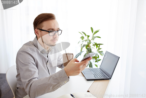 Image of businessman with smarphone and coffee at office