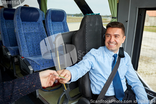 Image of bus driver taking ticket or card from passenger