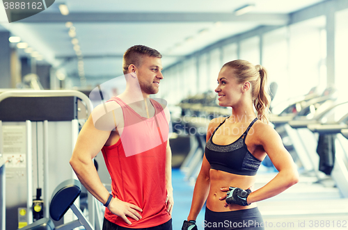 Image of smiling man and woman talking in gym