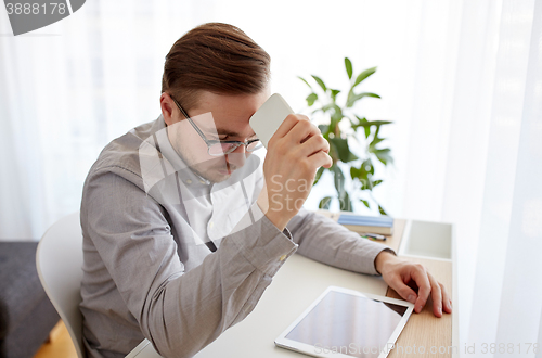 Image of businessman with smarphone at home office